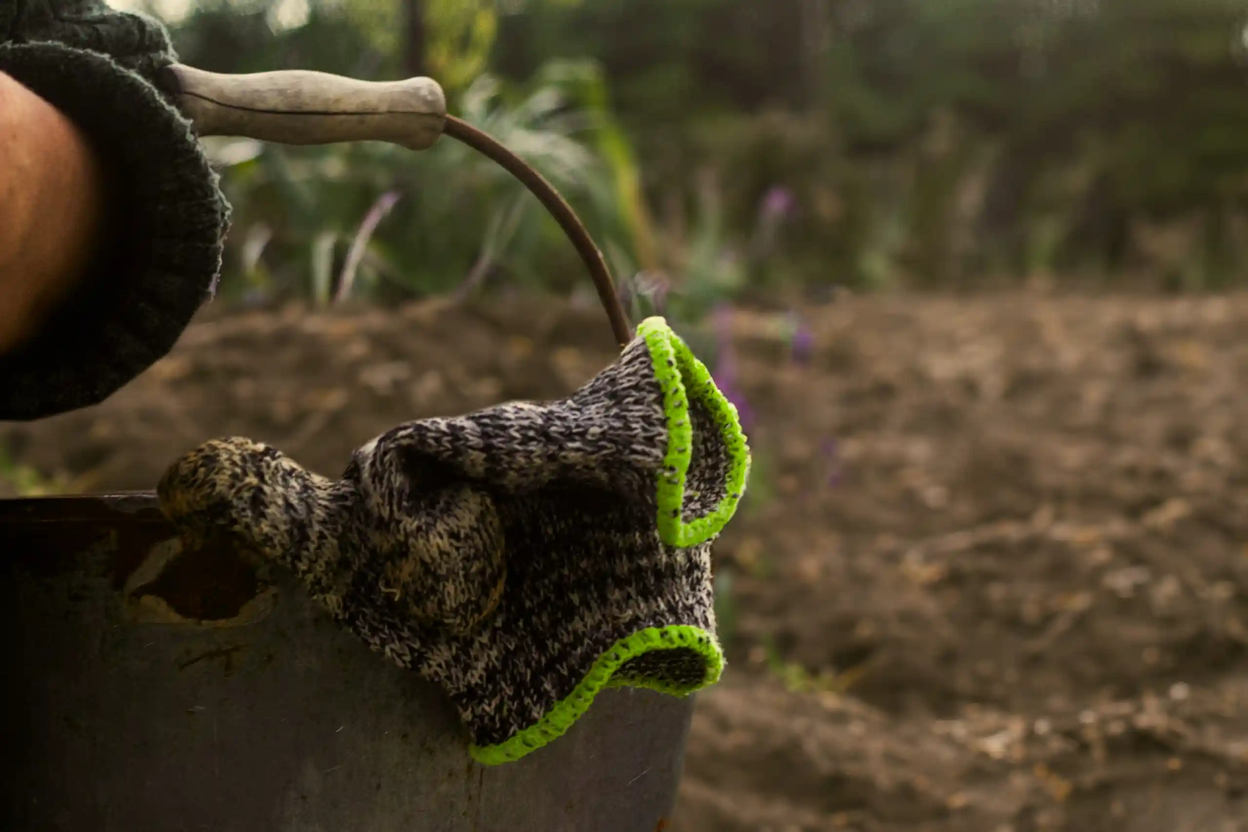 a bucket on the ground with gloves